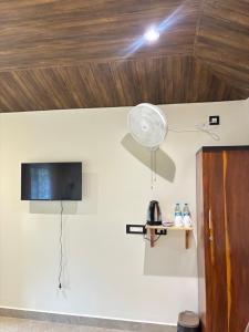 a room with a wall with a tv and a fan at The Hillshade villa in Borpāni