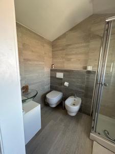 a bathroom with a toilet and a sink and a shower at Summer Nest in Cecina
