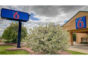 a sign for a gas station next to a bush at Motel 6 Elkhart, IN in Elkhart