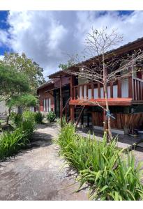 ein Gebäude mit einem Baum davor in der Unterkunft Datu Villa Sembalun in Sembalun Lawang