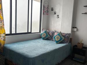 a room with a bed with pillows and a window at Bravo Hills in Gauhāti