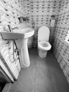 a bathroom with a toilet and a sink at Bravo Hills in Gauhāti