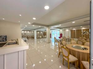 a lobby with a dining room with tables and chairs at Hotel Luxury Palace in Ishull-Lezhë