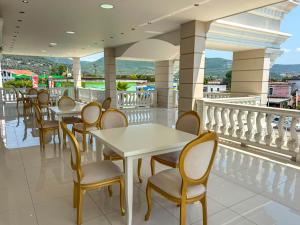 a restaurant with tables and chairs on a balcony at Hotel Luxury Palace in Ishull-Lezhë