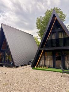 a house with a black roof and a chair at AFRAME Solotvino in Solotvyno