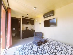 a bedroom with a bed and a chair and a television at KOARI - Studio Clim, Piscine in Auch