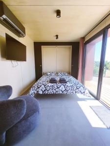 a bedroom with a bed in a room with windows at KOARI - Studio Clim, Piscine in Auch