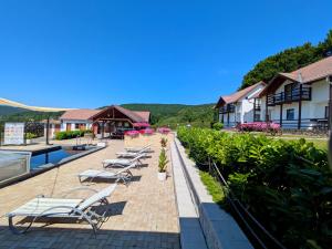 Eine Reihe von Liegestühlen auf einer Terrasse in einem Ferienresort in der Unterkunft PALLOS Retreat & Wellness in Sovata