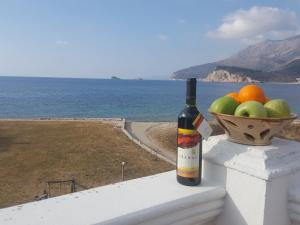 a bottle of wine sitting on a ledge with a bowl of fruit at Buljarica Bay Apartments in Petrovac na Moru
