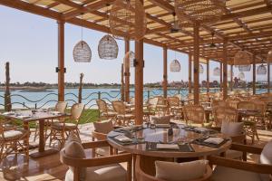 a restaurant with tables and chairs and a view of the water at Steigenberger Golf Resort El Gouna in Hurghada