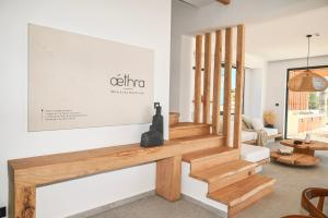 a living room with wooden stairs and a couch at Aethra Villa - Infinity Pool & Panoramic Sea View in Pefki