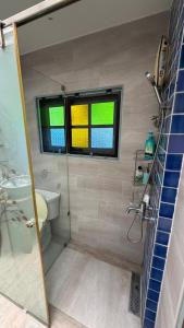 a bathroom with a shower and a toilet and a window at Cozy two-storey home in Ban Lam Praya Phai Rua +4 photos