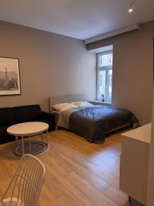a bedroom with a bed and a table and a couch at Furman's Court in Lublin