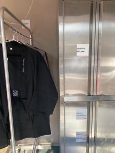 a black shirt on a rack next to a refrigerator at 8月1日オープン クリエイターズinn 宇野港近い トイレ風呂部屋にあり Uno collage in Tamano