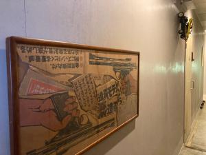 a picture hanging on a wall in a room at 8月1日オープン クリエイターズinn 宇野港近い トイレ風呂部屋にあり Uno collage in Tamano