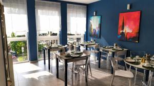 a dining room with tables and chairs and blue walls at Hotiday Ferrara Centro in Ferrara