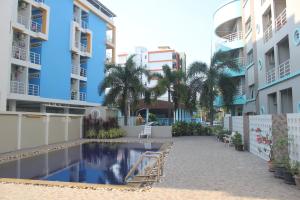 a swimming pool in the courtyard of a building at Lomsabai Apartments in Bangsaen