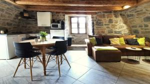 a living room with a couch and a table with chairs at Gorge du Tarn Loft Cocoon Lesoleilo in Mostuéjouls