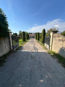an empty road with a fence and trees on either side at Logement en campagne in Bédarrides