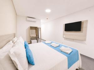a bedroom with a bed with a tv on the wall at Maragogi Praia Hotel in Maragogi
