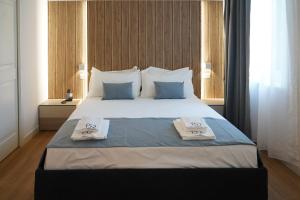 ein Schlafzimmer mit einem großen Bett, auf dem zwei Handtücher liegen in der Unterkunft Hotel F52 in Parma