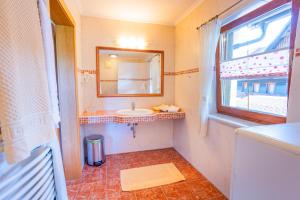 a bathroom with a sink and a mirror and a window at Minzlhof in Ramsau am Dachstein