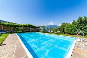a swimming pool in a backyard with mountains in the background at Krebishof Agriturismo in Schenna