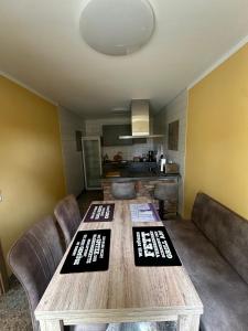a living room with a wooden table and a kitchen at Ferienwohnung Vorsicht Hotel in Deyelsdorf