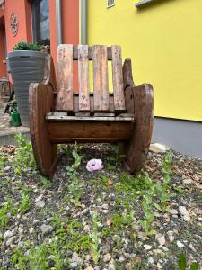 a wooden bench sitting next to a building at Ferienwohnung Vorsicht Hotel in Deyelsdorf