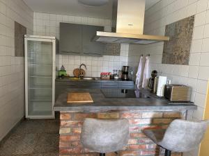 a kitchen with a counter and two chairs in it at Ferienwohnung Vorsicht Hotel in Deyelsdorf