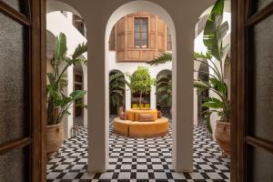 a hallway with a couch in a room with plants at The Mellah Hotel in Marrakesh