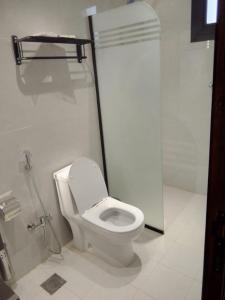 a bathroom with a white toilet and a shower at فندق نوفا ستاي in Nughaylah +5 photos