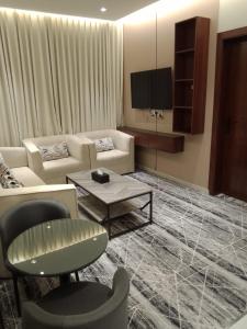 a living room with a couch and a tv at فندق نوفا ستاي in Nughaylah