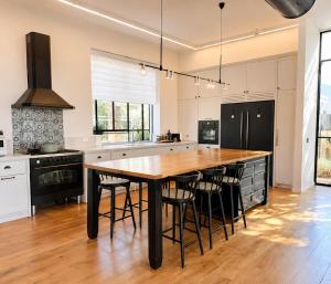 a kitchen with a large wooden table and chairs at Casa del Barone - וילה יוקרתית עם בריכה פרטית in Kefar Tavor