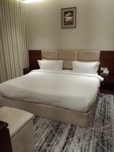 a bedroom with a large white bed in it at فندق نوفا ستاي in Nughaylah