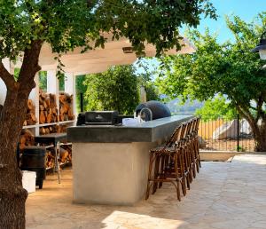 a outdoor kitchen with a table and chairs under a tree at Casa del Barone - וילה יוקרתית עם בריכה פרטית in Kefar Tavor