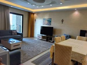 a living room with a table and a tv at Chalet Marina 2 Marassi in El Alamein