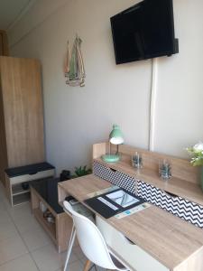 a room with a table and a tv on the wall at Studio Nicki Chania in Chania