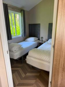 two twin beds in a room with a window at Zonnestraal in Harderwijk +20 photos