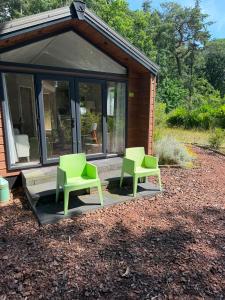two green chairs sitting on a patio in front of a house at Zonnestraal in Harderwijk