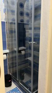 a shower with a glass door in a bathroom at Gió guest house in La Caletta