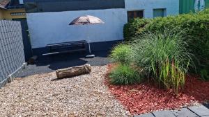 a patio with a bench and an umbrella at Ferienhaus Spengler in Beuren