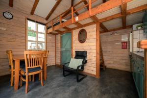 a room with a table and chairs in a cabin at Kampeerhut met gedeeld sanitair in Wintelre