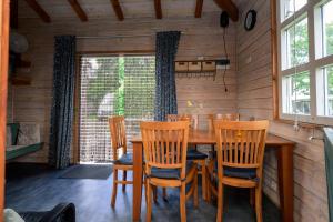 a dining room with a wooden table and chairs at Kampeerhut met gedeeld sanitair in Wintelre