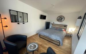 a bedroom with a bed and a clock on the wall at Le Parvis de PONT-AVEN in Pont-Aven
