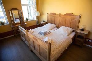 a bedroom with a large wooden bed with white pillows at Villa Weißbach - Haus Hilda in Flöha