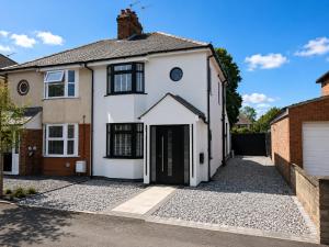 a white house with a driveway at Super Modern 3 bedroom semi-detached. in Rugby