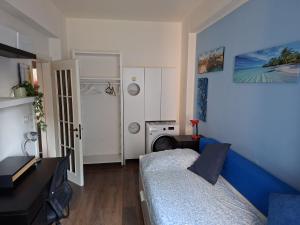 a small bedroom with a blue bed and a washing machine at Home G & D in Monza