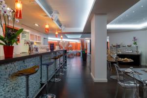 a bar in a restaurant with a counter and stools at Le Rex Hôtel in Tarbes