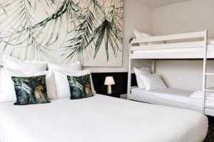 a bedroom with two bunk beds and a palm tree mural at Hôtel-Restaurant La Belle Poule - in Rochefort